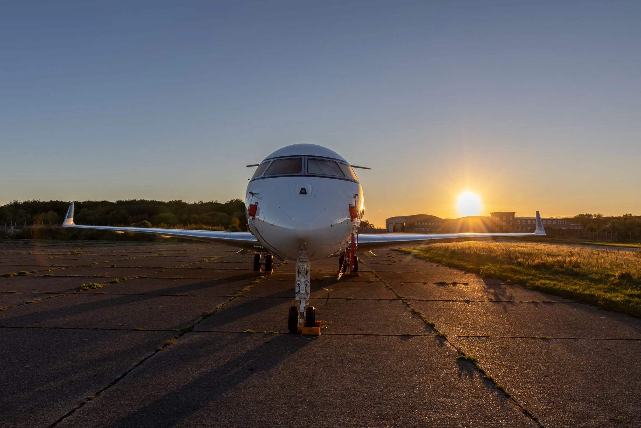 A business jet on an airfield in warm evening light