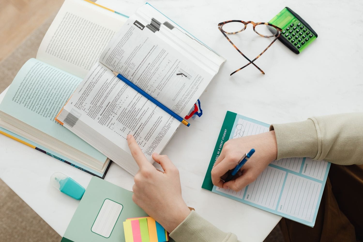 Student organising notes and working through a study planner
