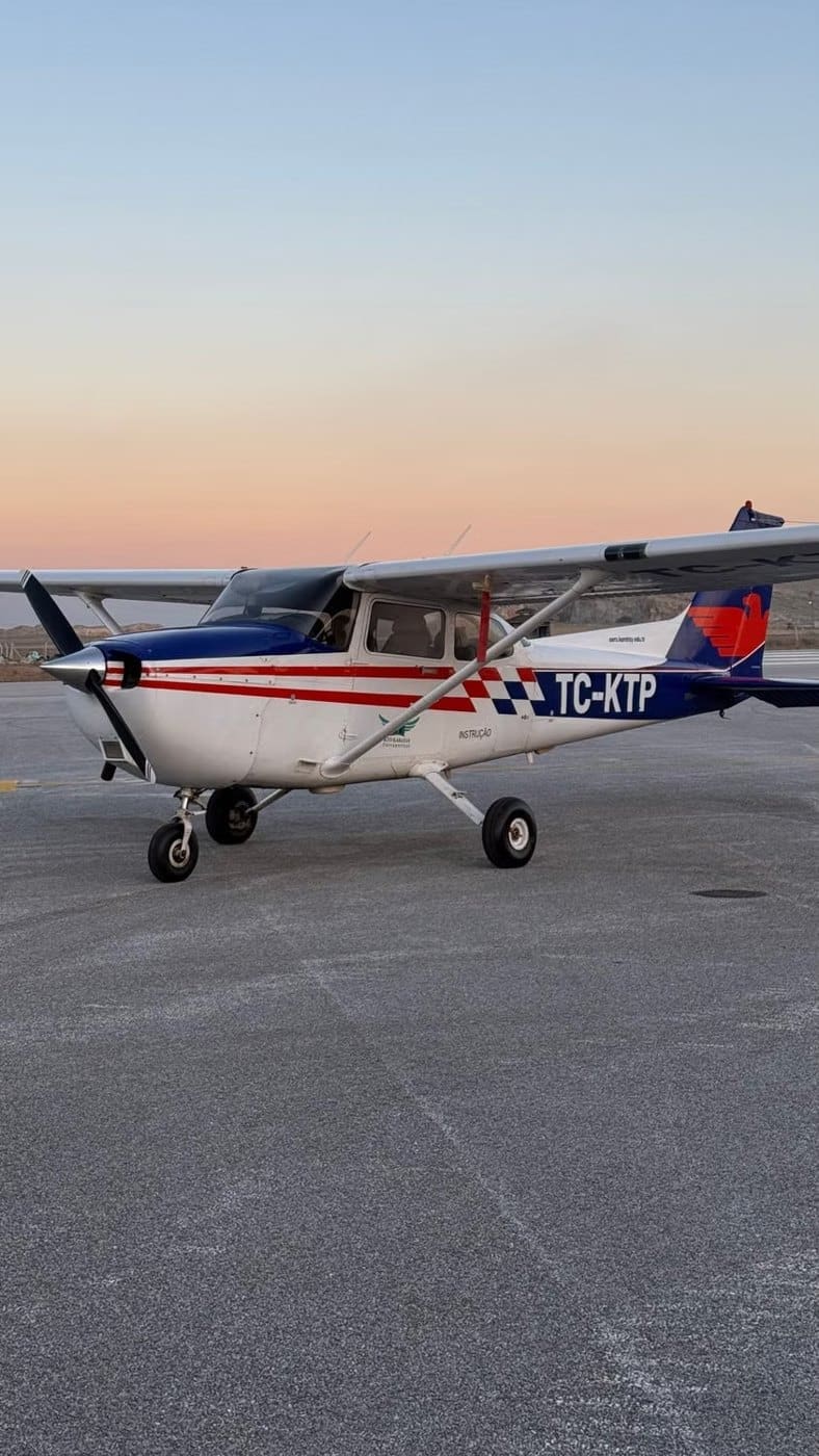Light aircraft on a runway beside green countryside