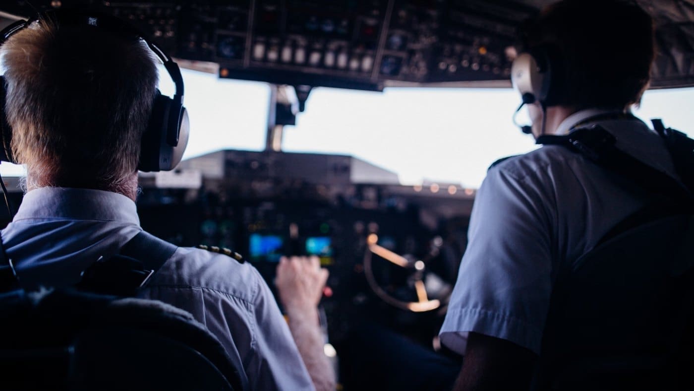 Two pilots working together in an airliner cockpit